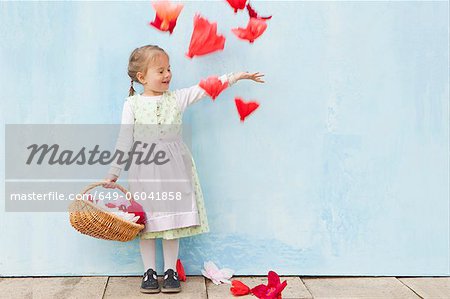 Jeune fille souriante, jouer avec des fleurs en papier