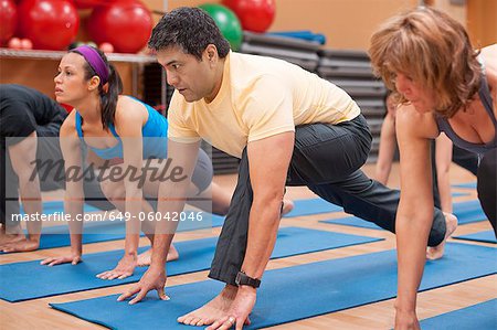 Personnes pratiquant l'yoga en studio