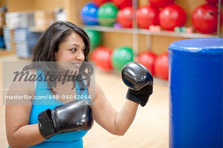 Woman punching bag in gym
