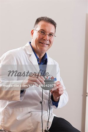 Audiologist holding a hearing aid device programmer