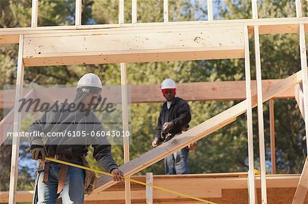 Carpenter measuring width of picture window frame