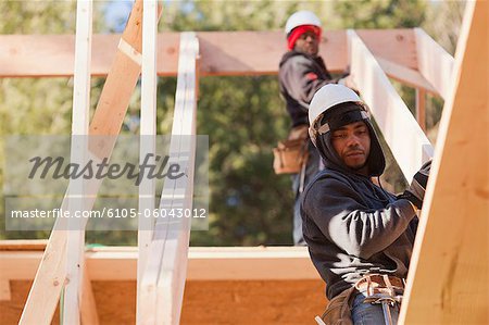 Carpenter placing a roof rafter