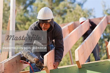 Carpenter nailing a roof rafter