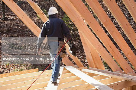 Zimmermann mit einem Bolzenschußgerät auf Dachebene