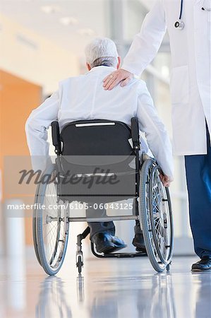 Docteur tapotant un autre sur le dos en fauteuil roulant avec la dystrophie musculaire