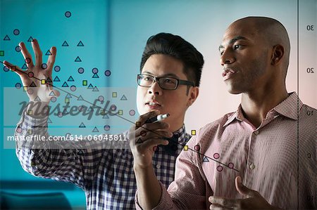 Two people looking at diagram on window Two people looking at diagram on window