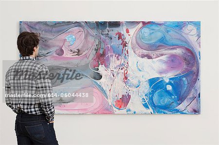 Jeune homme regardant la peinture à l'huile dans la galerie