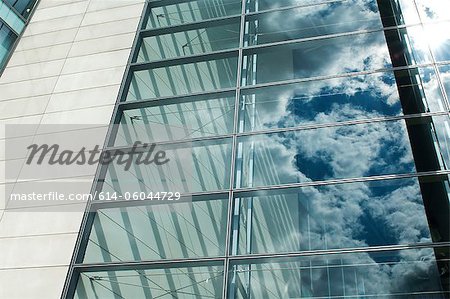 Ciel bleu nuageux, reflétée dans les fenêtres des bureaux