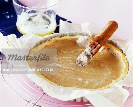 Brushing onto the pastry the beaten egg whites