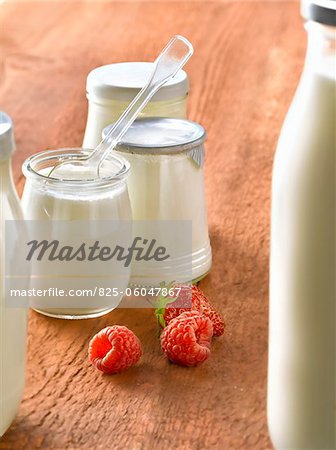 Yoghurts in glass pots and raspberries