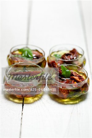 Olivenöl mit getrockneten Tomaten und Basilikum