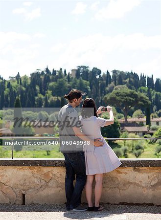 Italy, Florence, Young couple photographing rural landscape