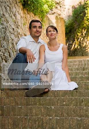 Italy, Ravello, Couple sitting on steps in old town