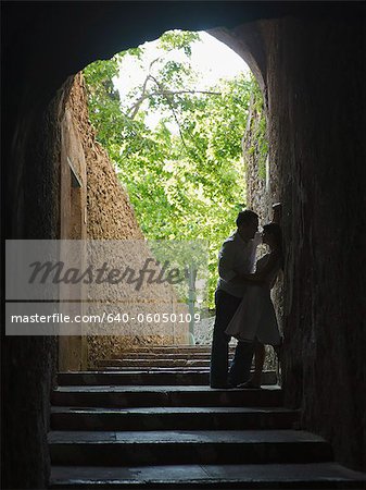 Italy, Ravello, Mature couple kissing in archway