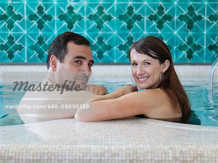 Italy, Amalfi Coast, Ravello, Mature couple looking over shoulder in swimming pool