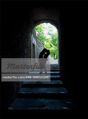 Italy, Venice, Young couple kissing in archway