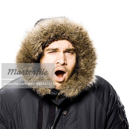 Mann trägt einen Wintermantel mit Kapuze Fell getrimmt