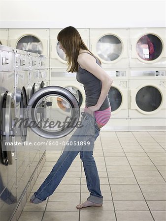 Frau ihre Kleider auf den Waschsalon