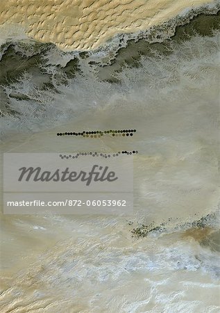 Agriculture dans le désert de Murzuq en 1987, la Libye, l'Image Satellite couleur vraie. Image satellite de couleur vraie de l'agriculture dans le nord du désert de Murzuq en Libye. Le désert de Murzuq est un désert de l'erg, une partie du désert du Sahara, dans le sud-ouest de la Libye. Les parcelles agricoles circulaires sont visibles sur l'image. Image prise le 13 janvier 1987, à l'aide de données LANDSAT 5.