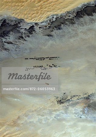 Agriculture dans le désert de Murzuq en 2000, la Libye, l'Image Satellite couleur vraie. Image satellite de couleur vraie de l'agriculture dans le nord du désert de Murzuq en Libye. Le désert de Murzuq est un désert de l'erg, une partie du désert du Sahara, dans le sud-ouest de la Libye. Les parcelles agricoles circulaires sont visibles sur l'image. Image prise le 8 novembre 2000, à l'aide de données LANDSAT 7.