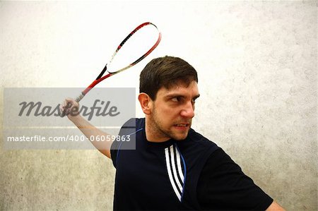 A handsome man playing squash in the hall