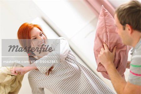 Happy couple having pillow fight