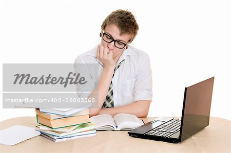 teenager student sits behind a desk isolated on white background