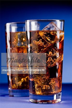 Photo of delicious cold glass with cola and ice cubes