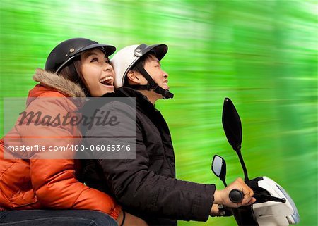 happy couple riding on the bike at spring time