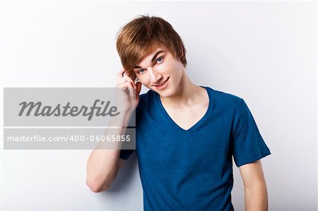 Portrait of a casual young man over a white wall, thinking in something