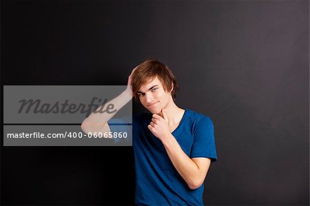 Portrait of a young man thinking over a black chalk board