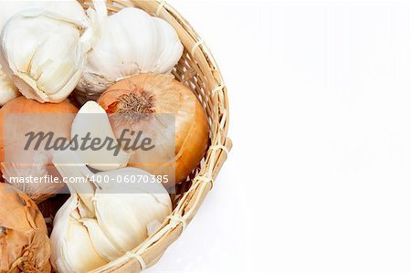 Onion and garlic clove in basket isolated on white background