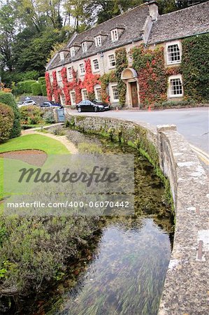 quaint traditional golden limestone style english country pub and hotel in the cotswalds village of Bibury in Gloucestershire England