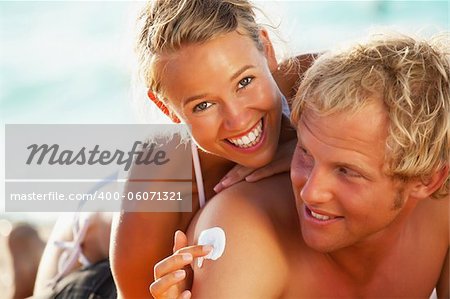Lifestyle portrait of a happy young couple on the beach. Focus on girl.