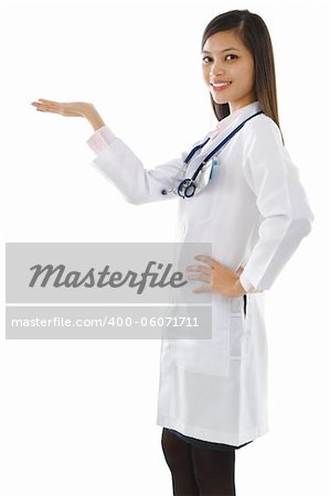 Happy cheerful beautiful Asian young Doctor holding her hand out and showing copy space for your product.