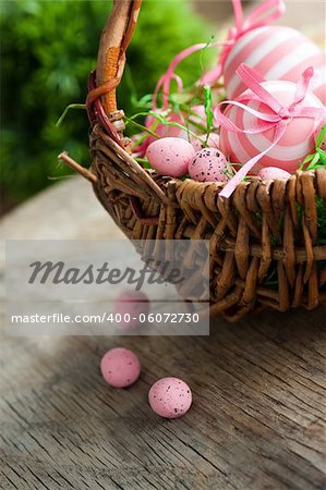 Colorful Easter holiday concept with pink eggs in wisker basket in nature