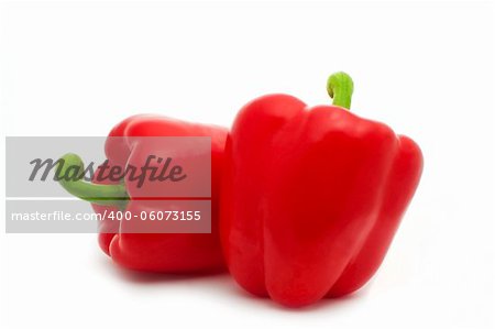 two fresh red peppers isolated over white