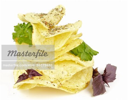 Potato Chips pyramid with basil and parsley isolated on white background