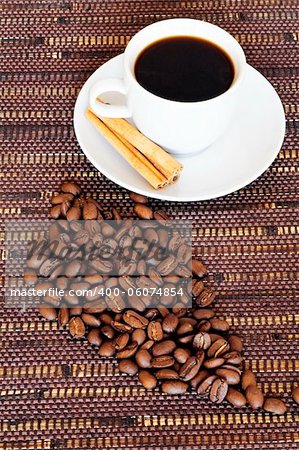 White cup and coffee beans on a dark wattled background