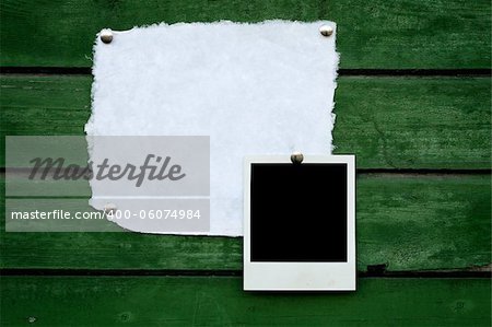 Handmade paper and instant photo on green wooden background