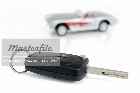 A car key isolated on white background with a car toy