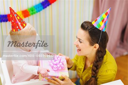 Mother giving birthday gift for baby