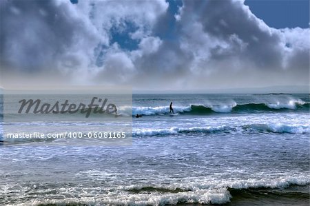 beautiful clean atlantic ocean with surfers catching the waves during a storm on Irelands coast
