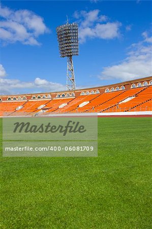 football field with light stand and orange seats