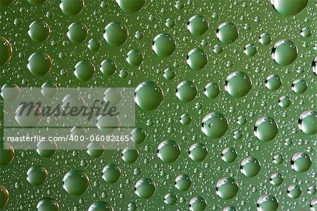 Close up of water drops on green glass surface as background