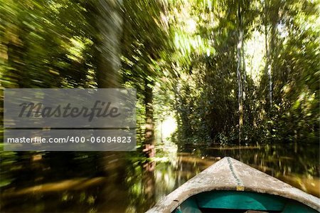 Canoe with motion blur paddling up a river