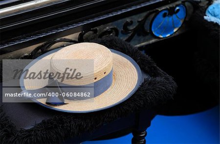 Image of a hat of a gondolier on a specific chair in a gondola.