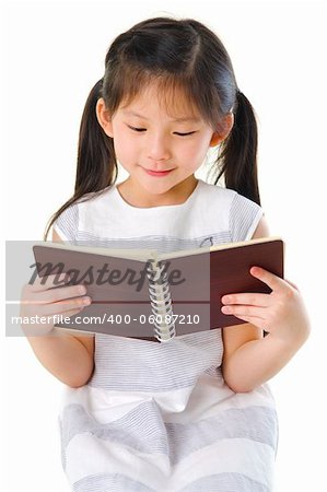 Little Asian girl reading on white background