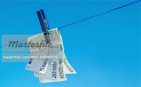 concept of  money hanging on clothesline against blue sky