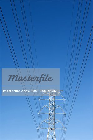 High voltage power pole against blue sky